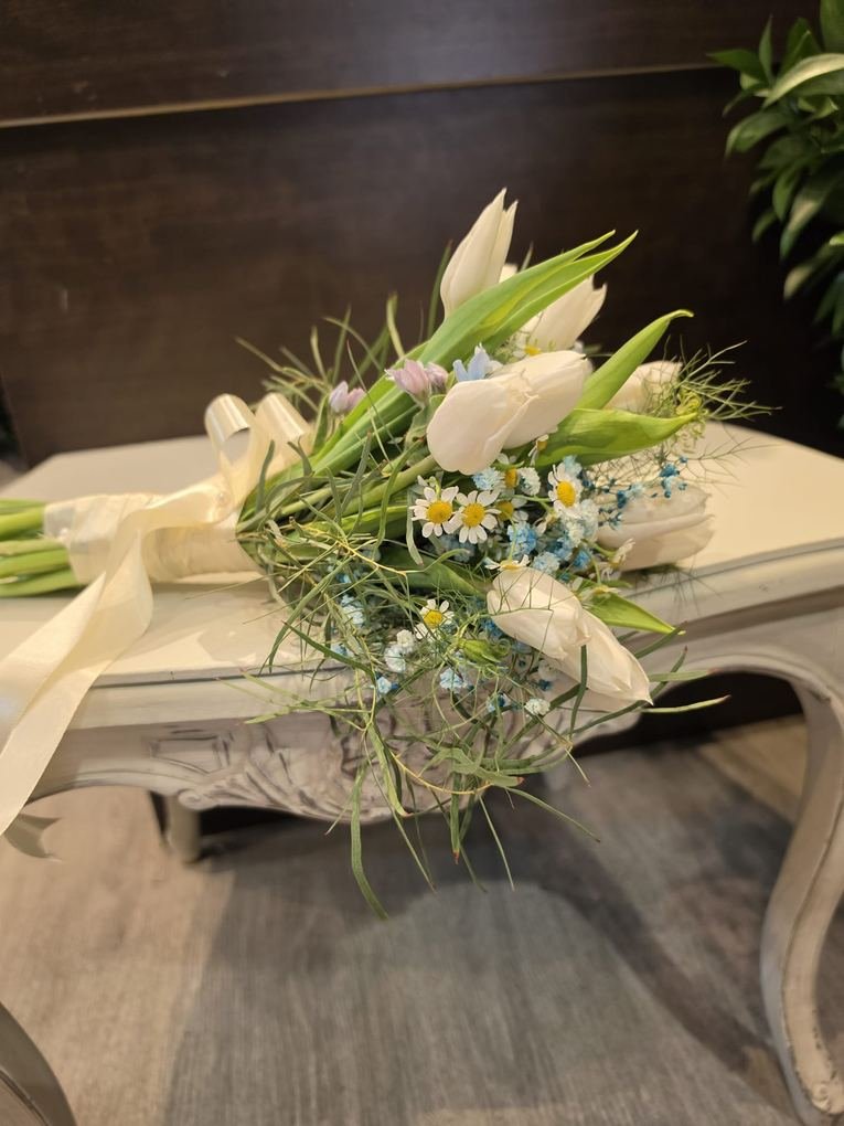 Ramo de novia de tulipanes blancos y margaritas atado con lazo de raso